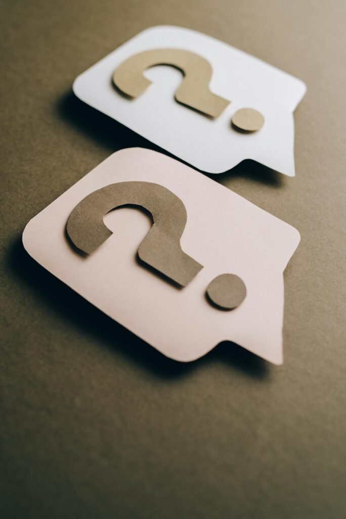 pexels-photo-5428832-5428832-1 Two paper craft question marks on speech bubbles create a conceptual visual.